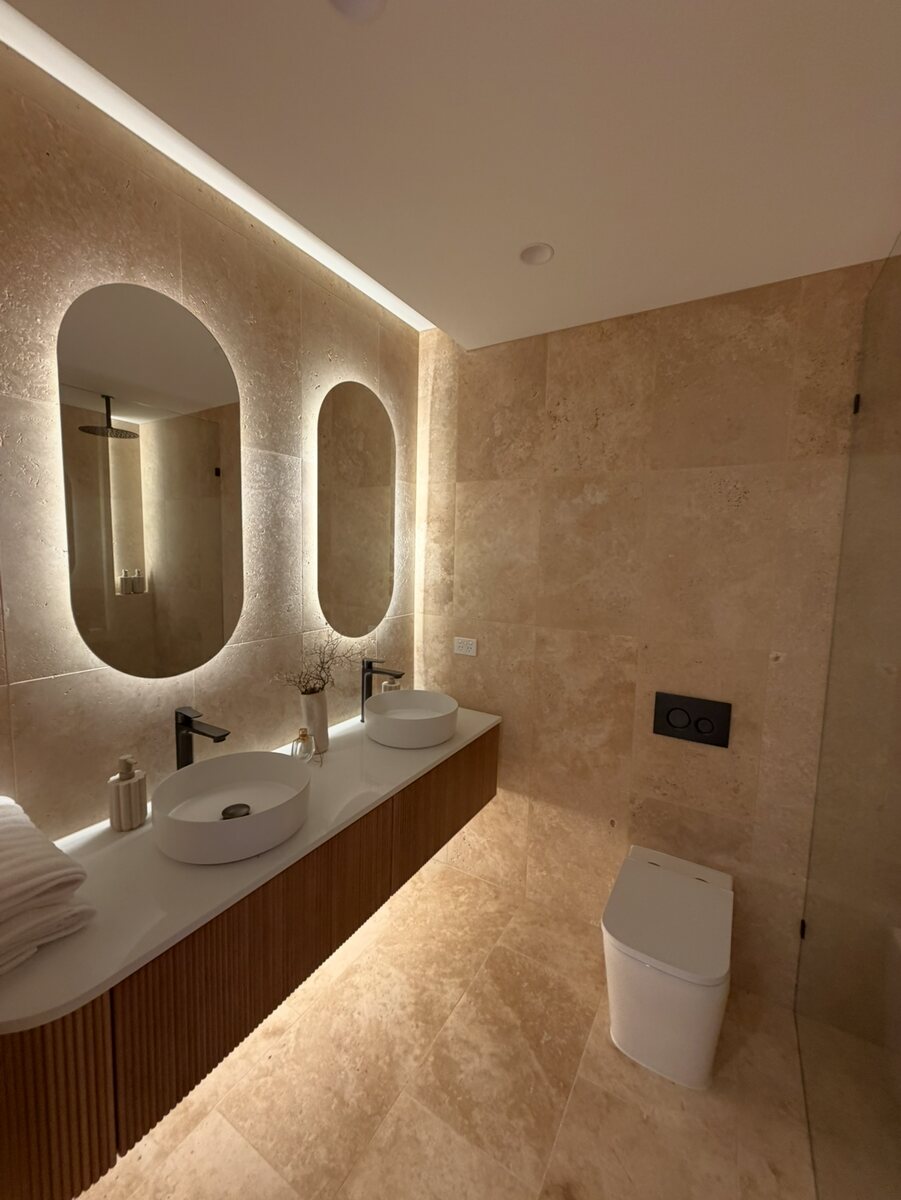 Finished bathroom installation with illuminated mirrors and concealed lighting